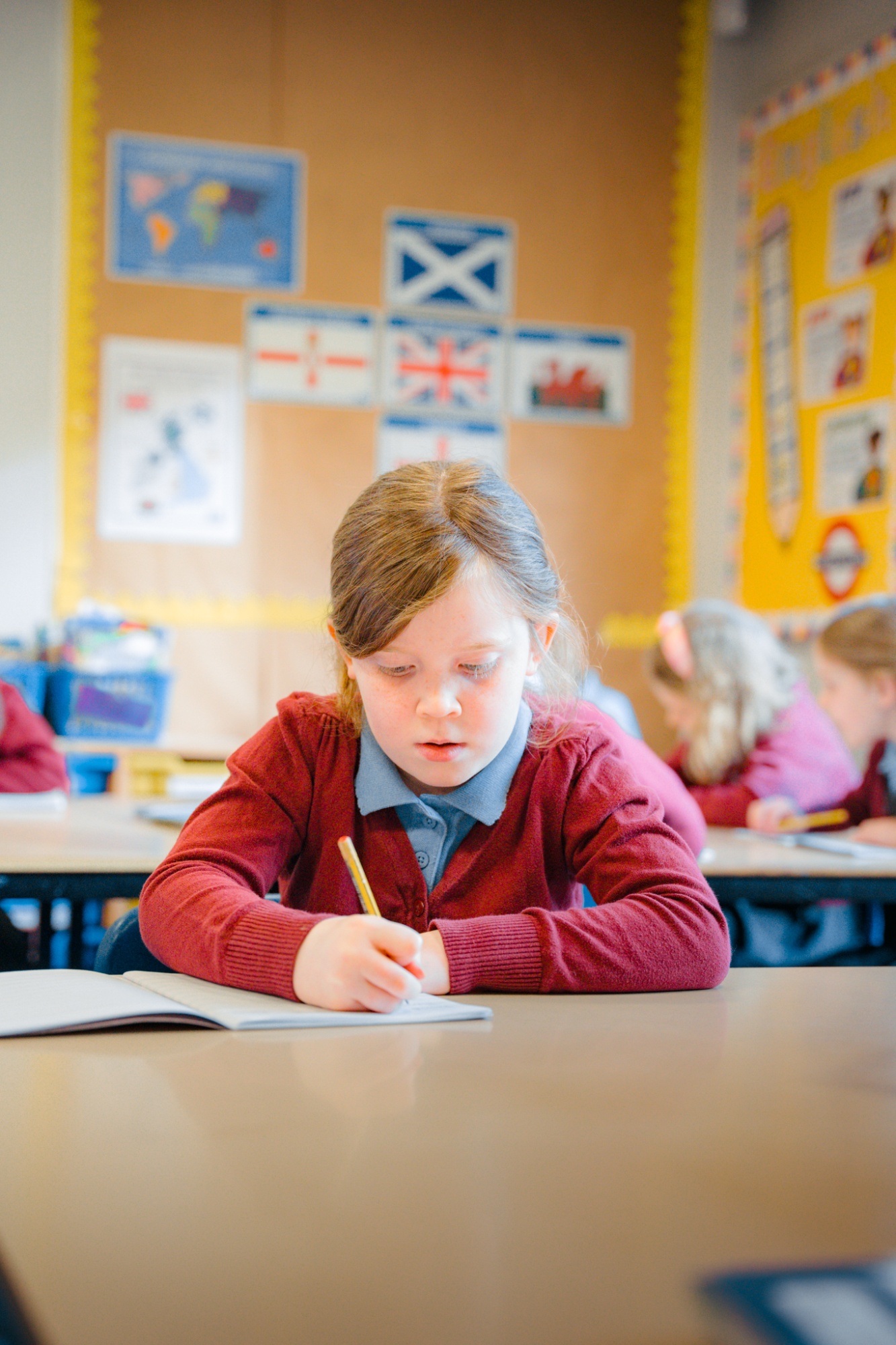 student writing in their school book in classroom