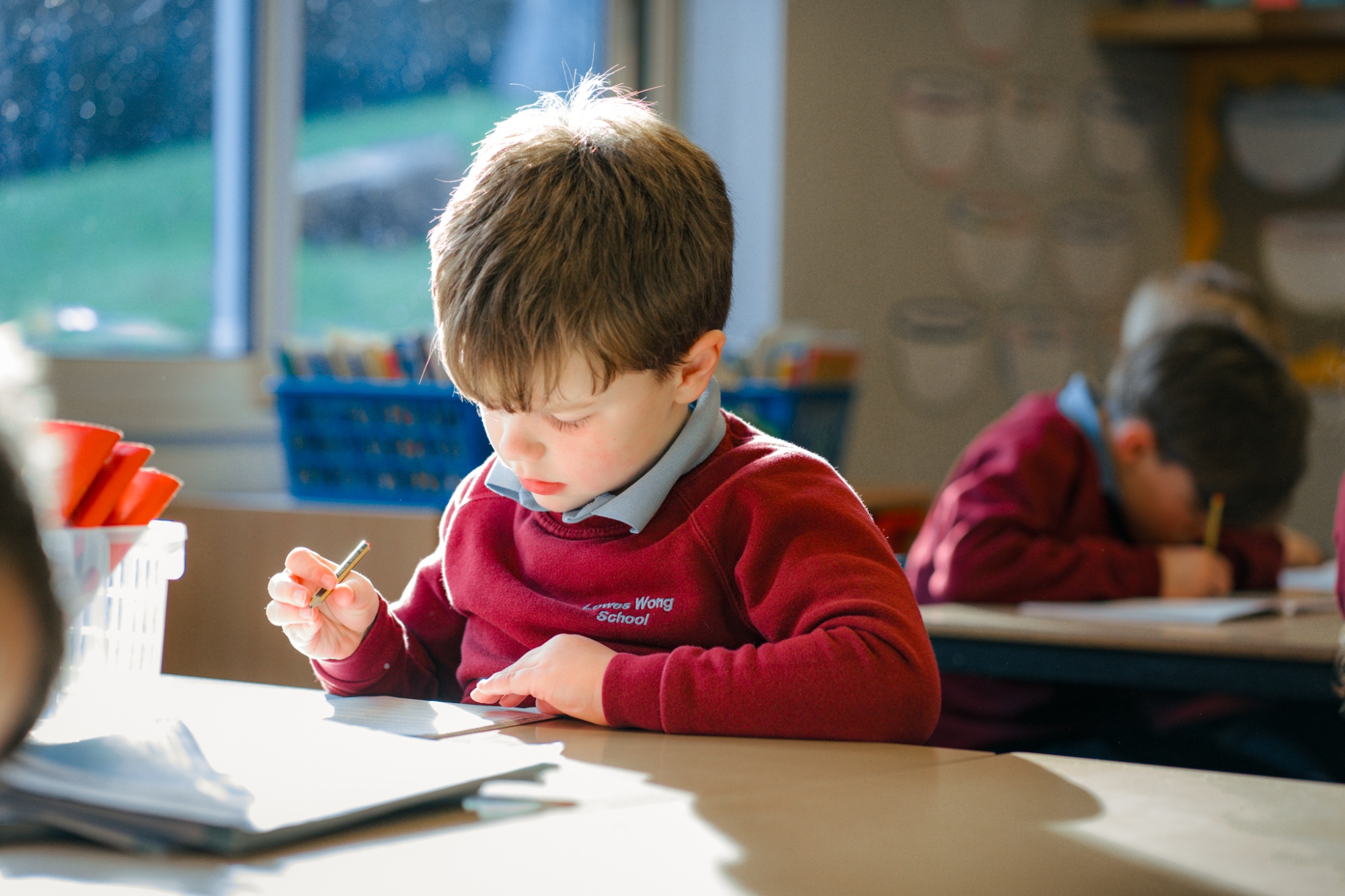 student working in text book in classroom
