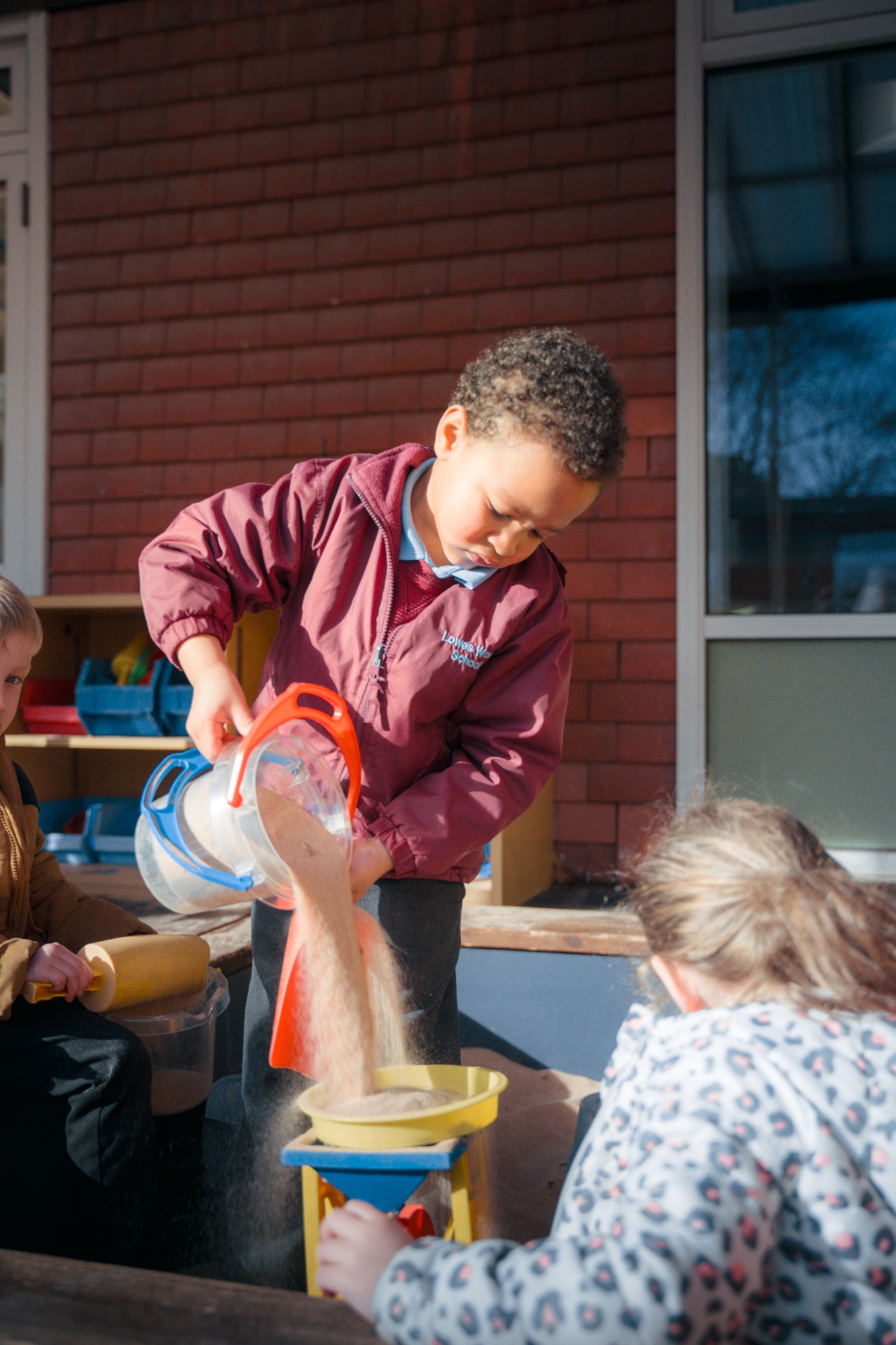 students playing in sandpit at break time