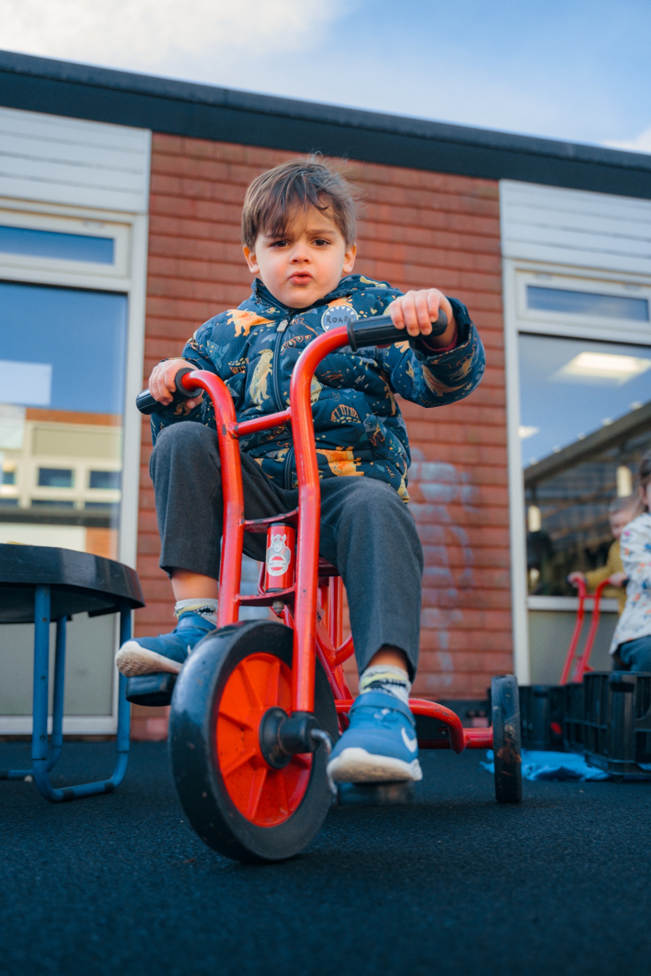student looking at camera while riding scooter outside